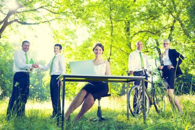 Deux chaises en bois et une table ronde avec un seau à glace sur une terrasse donnant sur un jardin verdoyant.