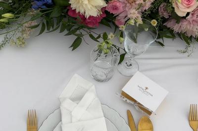 Une mariée en tailleur blanc tenant un bouquet devant une vitrine avec l'inscription ’Love Curated’.