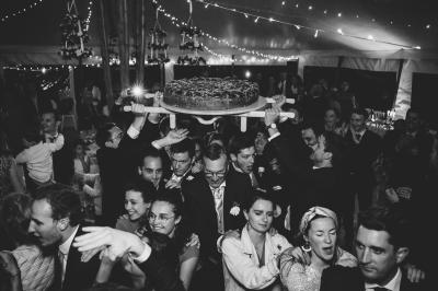 Un homme en costume bleu se tient debout sur une terrasse extérieure par temps nuageux.