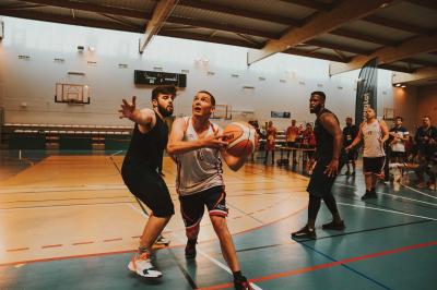 Un homme en costume bleu se tient debout sur une terrasse extérieure par temps nuageux.