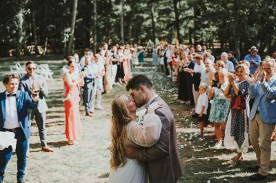Des personnes en tenue élégante regardent des danseuses en maillot de bain et bonnet, lors d'un événement en extérieur.