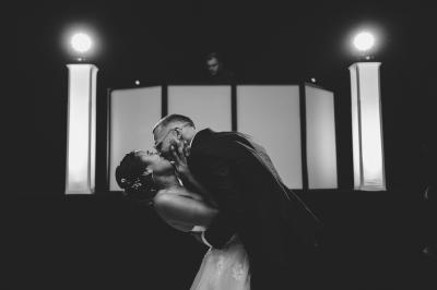 Des personnes en tenue élégante regardent des danseuses en maillot de bain et bonnet, lors d'un événement en extérieur.