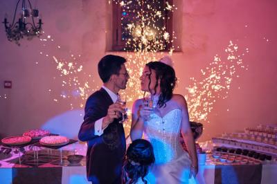 Corset blanc en dentelle et satin éclairé par des lumières vertes et violettes dans un environnement sombre.