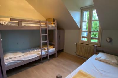 Miniature Location salle Sergenaux (Jura) - La Maison des Etangs #6 Salle de réunion lumineuse avec tables disposées en U et chaises orange, entourée de grandes fenêtres.