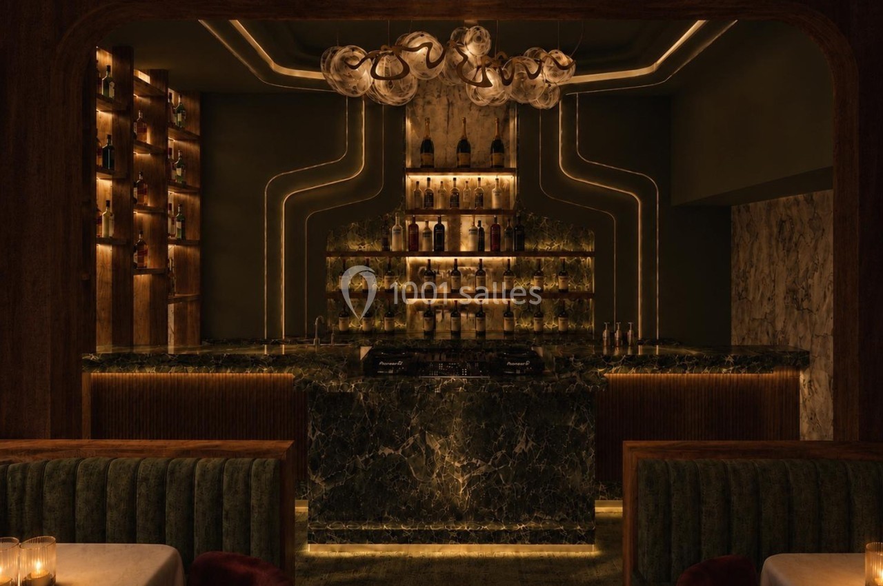 Bar élégant avec comptoir en marbre sombre, étagères rétroéclairées pour bouteilles et éclairage tamisé.