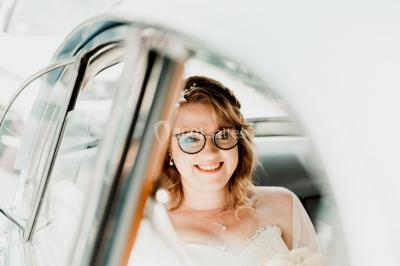 Miniature Au Bord des Yeux #8 Un couple s'embrasse en arrière-plan tandis qu'un bouquet de fleurs est mis au premier plan.