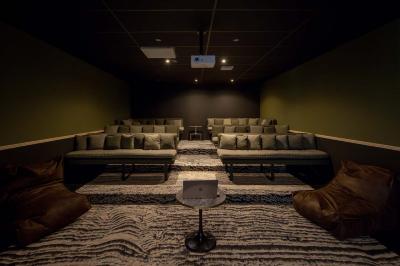 Terrasse moderne avec mobilier extérieur, vue sur une ville au coucher du soleil et ciel aux teintes orangées.
