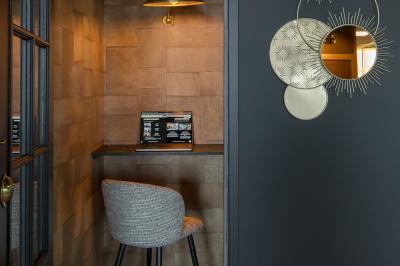 Terrasse moderne avec mobilier extérieur, vue sur une ville au coucher du soleil et ciel aux teintes orangées.