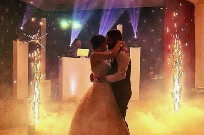 Miniature DJ Coulogne (Pas-de-Calais) - GreG évènements #15 Un couple danse dans une ambiance festive avec éclairages colorés, fumée et étincelles décoratives.