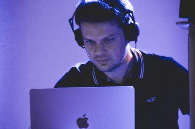 Miniature DJ Coulogne (Pas-de-Calais) - GreG évènements #9 Un DJ mixe sur un ordinateur portable, entouré de lumières colorées dans un décor en bois avec des bouées suspendues.