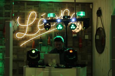 Miniature DJ Coulogne (Pas-de-Calais) - GreG évènements #15 Un DJ mixe sur un ordinateur portable, entouré de lumières colorées dans un décor en bois avec des bouées suspendues.