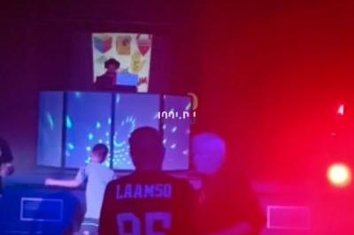 Installation de matériel de sonorisation et éclairage coloré dans une salle avec un fond de mur rouge.