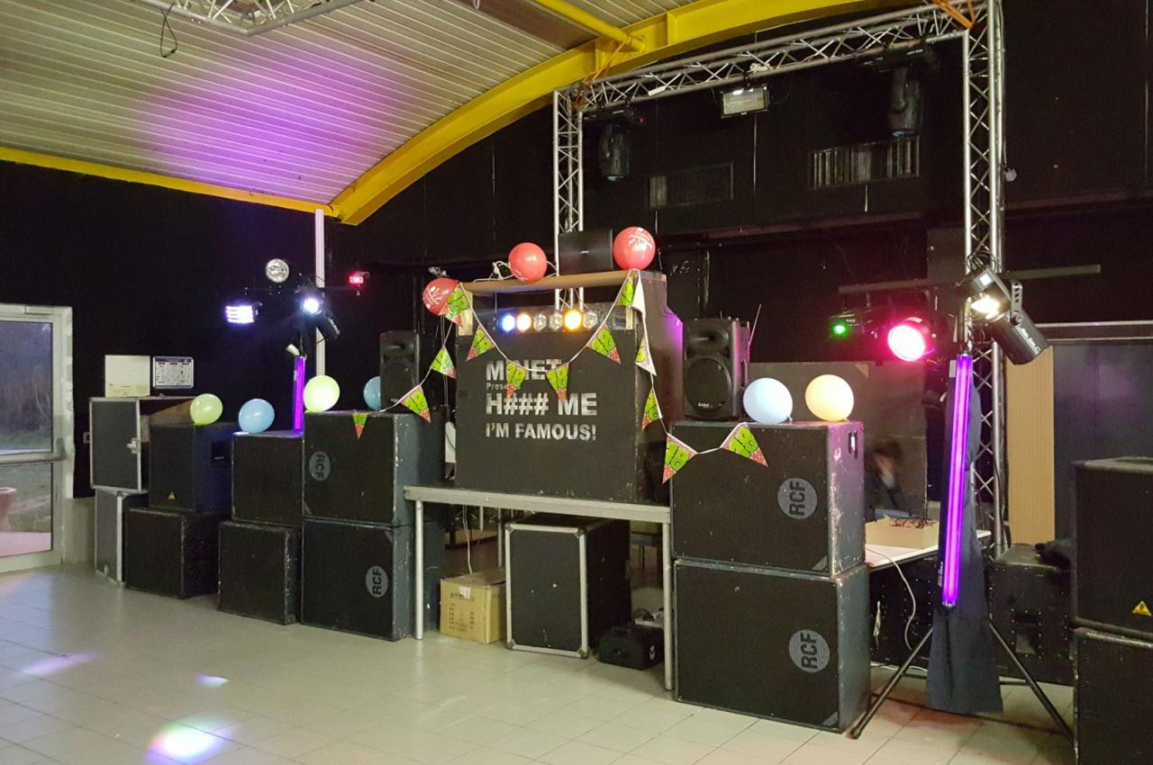 Installation de matériel audio et éclairage coloré dans une salle pour un événement festif.