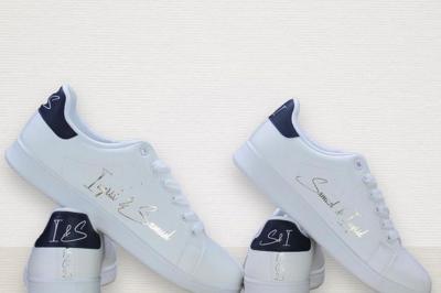 Flûte personnalisée avec le prénom ’Marion’ et bougie marquée ’50 ans’, posées sur une table devant un fond rose.