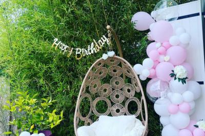 Flûte personnalisée avec le prénom ’Marion’ et bougie marquée ’50 ans’, posées sur une table devant un fond rose.