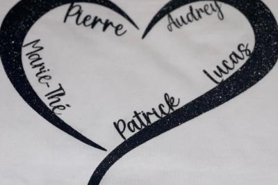 Flûte personnalisée avec le prénom ’Marion’ et bougie marquée ’50 ans’, posées sur une table devant un fond rose.