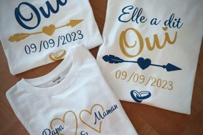 Flûte personnalisée avec le prénom ’Marion’ et bougie marquée ’50 ans’, posées sur une table devant un fond rose.