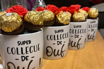 Flûte personnalisée avec le prénom ’Marion’ et bougie marquée ’50 ans’, posées sur une table devant un fond rose.