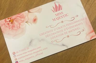 Flûte personnalisée avec le prénom ’Marion’ et bougie marquée ’50 ans’, posées sur une table devant un fond rose.