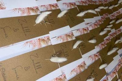 Flûte personnalisée avec le prénom ’Marion’ et bougie marquée ’50 ans’, posées sur une table devant un fond rose.