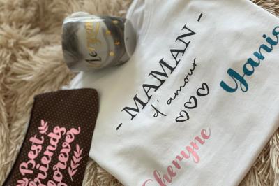 Flûte personnalisée avec le prénom ’Marion’ et bougie marquée ’50 ans’, posées sur une table devant un fond rose.