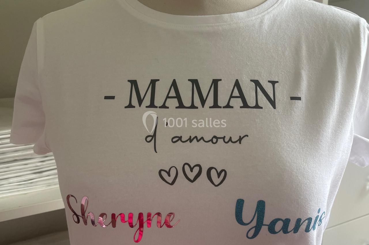 T-shirt blanc avec l'inscription ’MAMAN d'amour’ et les prénoms ’Sheryne’ et ’Yanis’ imprimés en couleurs.