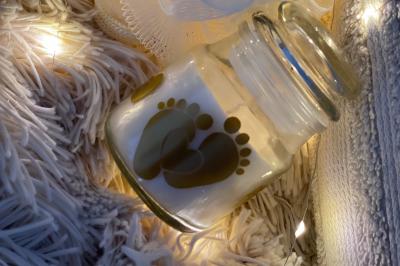 Flûte personnalisée avec le prénom ’Marion’ et bougie marquée ’50 ans’, posées sur une table devant un fond rose.