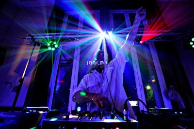 Miniature DJ Sallertaine (Vendée) - DjGo #2 Un homme en costume utilise une table de mixage lors d'un événement en extérieur, avec des ballons en arrière-plan.