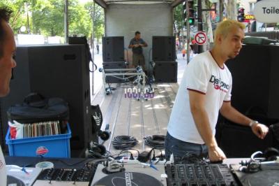 Miniature DJ Sallertaine (Vendée) - DjGo #11 Un homme en costume utilise une table de mixage lors d'un événement en extérieur, avec des ballons en arrière-plan.