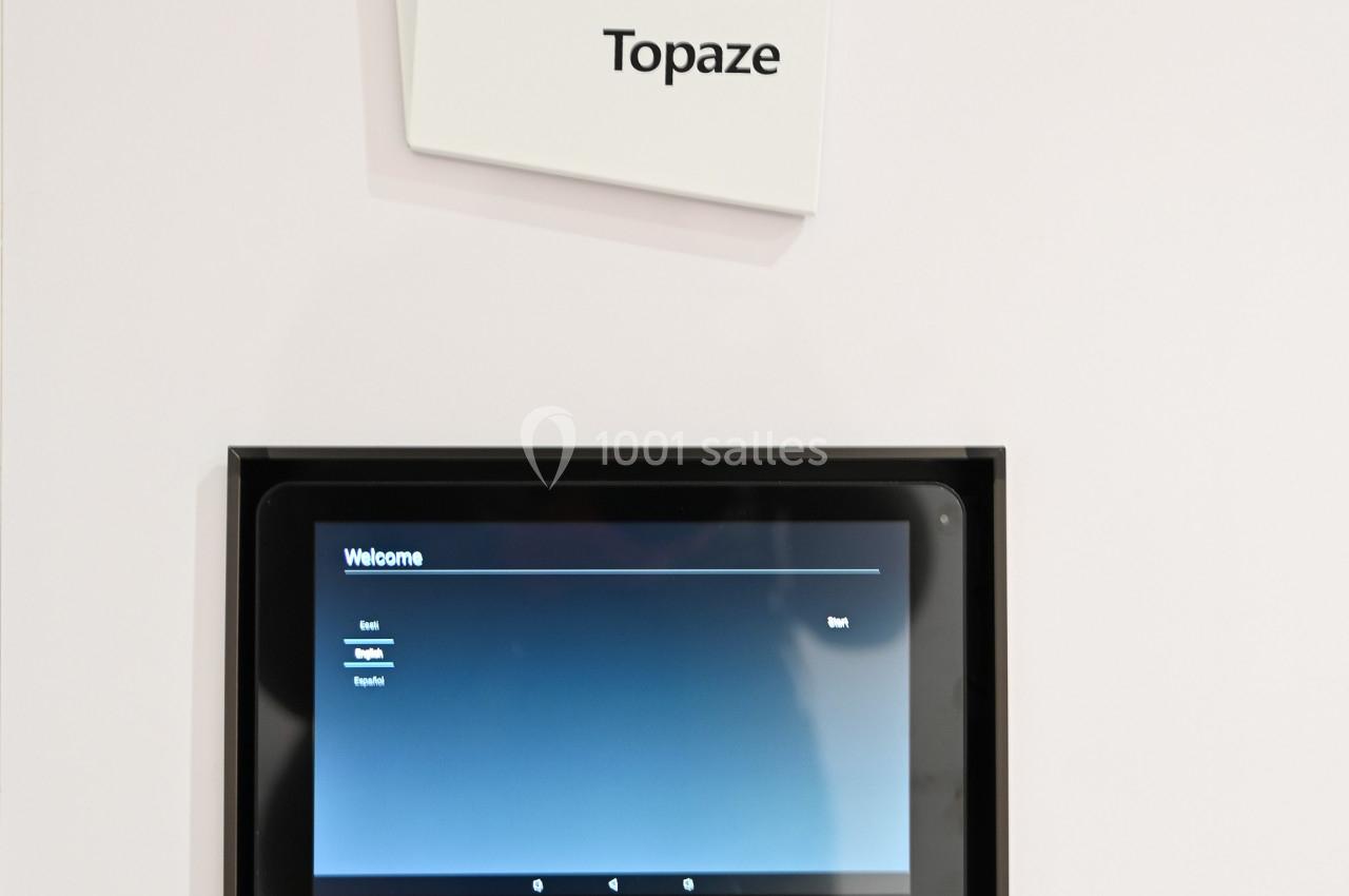 Panneau indiquant ’Salle Topaze’ avec une tablette tactile et un lecteur de badge en dessous.