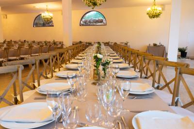 Vue aérienne d'une maison en pierre avec toit en tuiles, entourée d'arbres, d'une piscine et d'un chemin en gravier.
