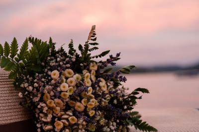 Femme portant une couronne de fleurs, regardant au loin devant un lac au coucher du soleil.