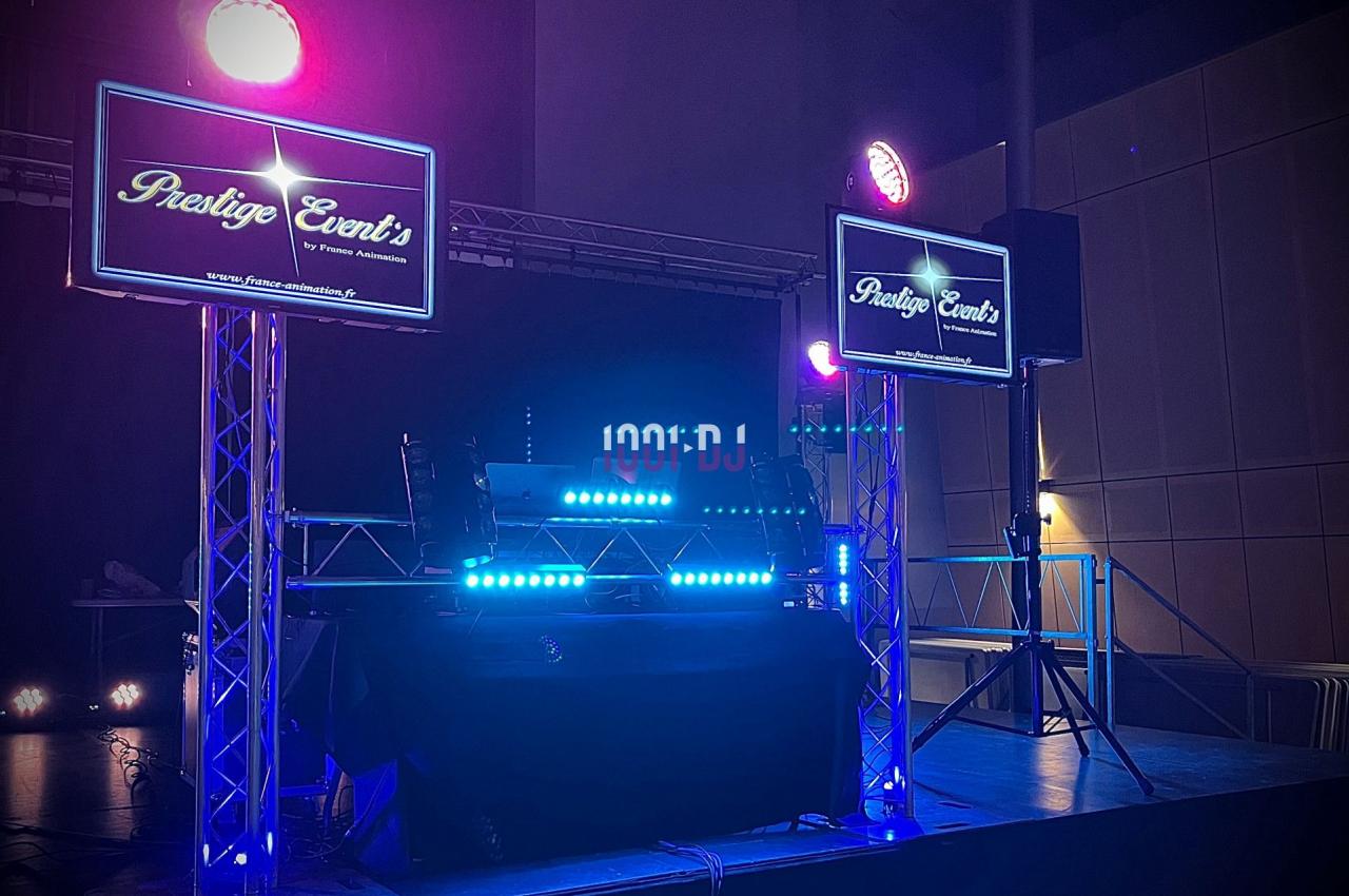 Installation de matériel de sonorisation et éclairage avec écrans affichant ’Prestige Event's’ dans une salle sombre.