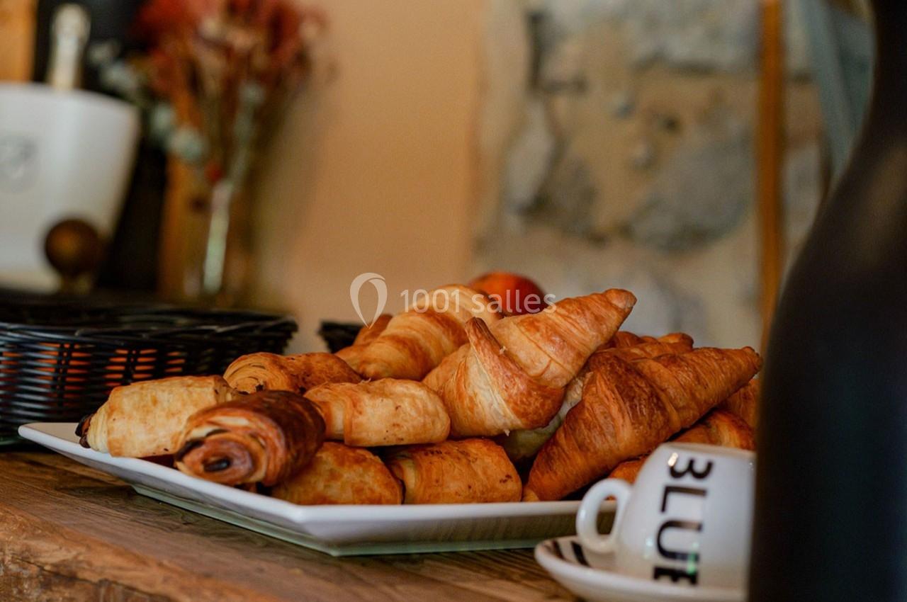Assortiment de viennoiseries disposé sur une assiette blanche, posé sur une table en bois.
