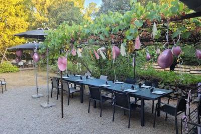 Lit double avec tête de lit en bois sculpté, draps blancs et serviettes pliées, dans une chambre aux murs en pierre.