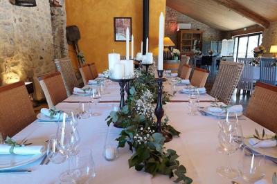 Lit double avec tête de lit en bois sculpté, draps blancs et serviettes pliées, dans une chambre aux murs en pierre.