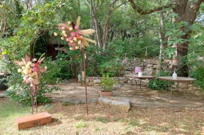 Lit double avec tête de lit en bois sculpté, draps blancs et serviettes pliées, dans une chambre aux murs en pierre.