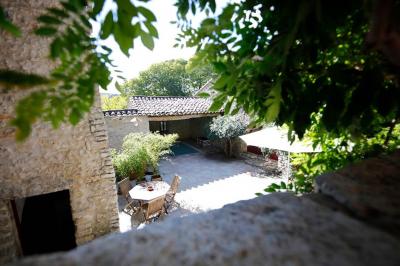 Lit double avec tête de lit en bois sculpté, draps blancs et serviettes pliées, dans une chambre aux murs en pierre.