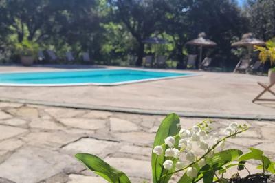 Lit double avec tête de lit en bois sculpté, draps blancs et serviettes pliées, dans une chambre aux murs en pierre.