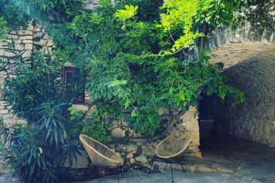 Lit double avec tête de lit en bois sculpté, draps blancs et serviettes pliées, dans une chambre aux murs en pierre.