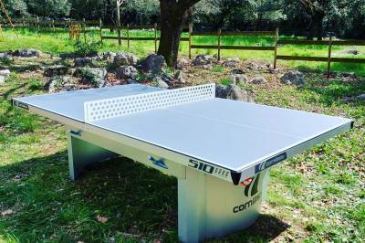 Lit double avec tête de lit en bois sculpté, draps blancs et serviettes pliées, dans une chambre aux murs en pierre.