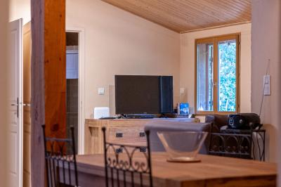 Lit double avec tête de lit en bois sculpté, draps blancs et serviettes pliées, dans une chambre aux murs en pierre.