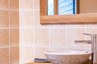 Lit double avec tête de lit en bois sculpté, draps blancs et serviettes pliées, dans une chambre aux murs en pierre.