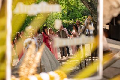 Lit double avec tête de lit en bois sculpté, draps blancs et serviettes pliées, dans une chambre aux murs en pierre.