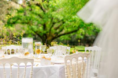 Lit double avec tête de lit en bois sculpté, draps blancs et serviettes pliées, dans une chambre aux murs en pierre.