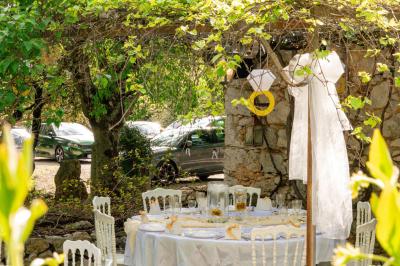Lit double avec tête de lit en bois sculpté, draps blancs et serviettes pliées, dans une chambre aux murs en pierre.