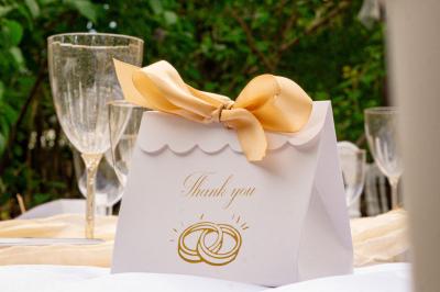 Lit double avec tête de lit en bois sculpté, draps blancs et serviettes pliées, dans une chambre aux murs en pierre.