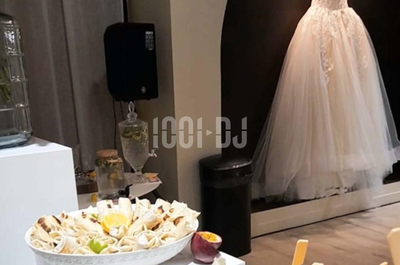 Assiette de wraps garnis posée sur une table, avec une robe de mariée exposée en arrière-plan.