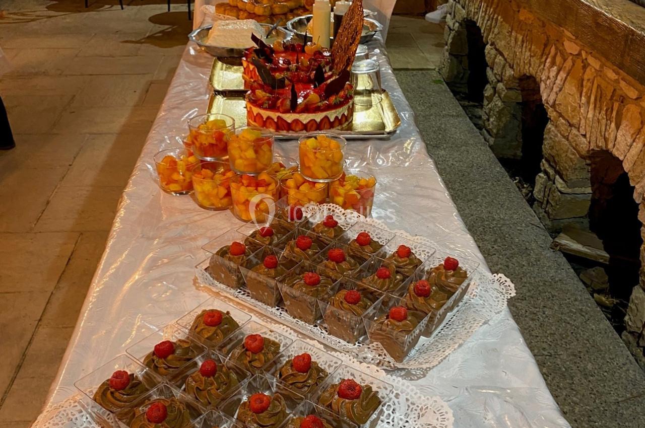 Table dressée avec des desserts variés, incluant des verrines de mousse au chocolat et des coupes de fruits frais.
