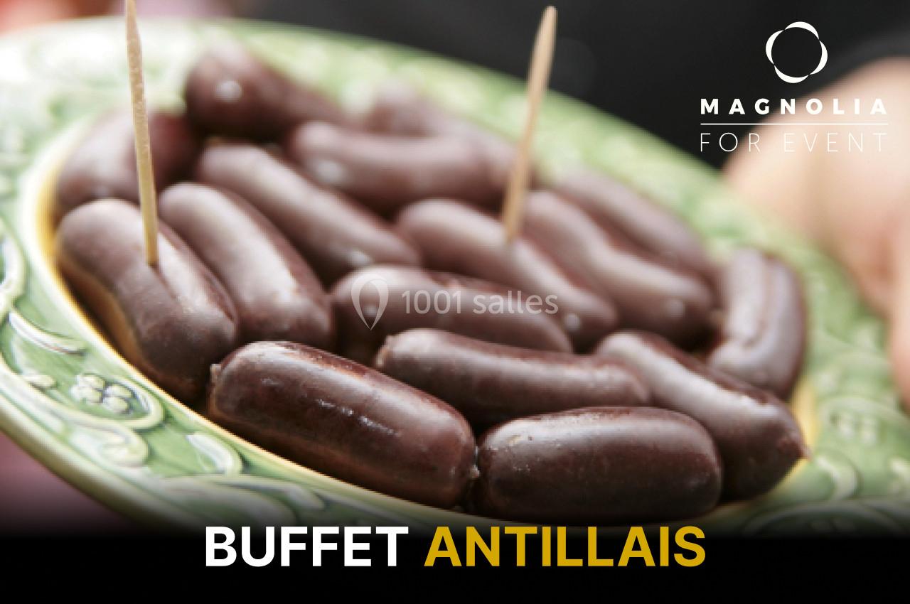 Assiette de boudins antillais présentés avec des piques en bois, sur un plat décoré.